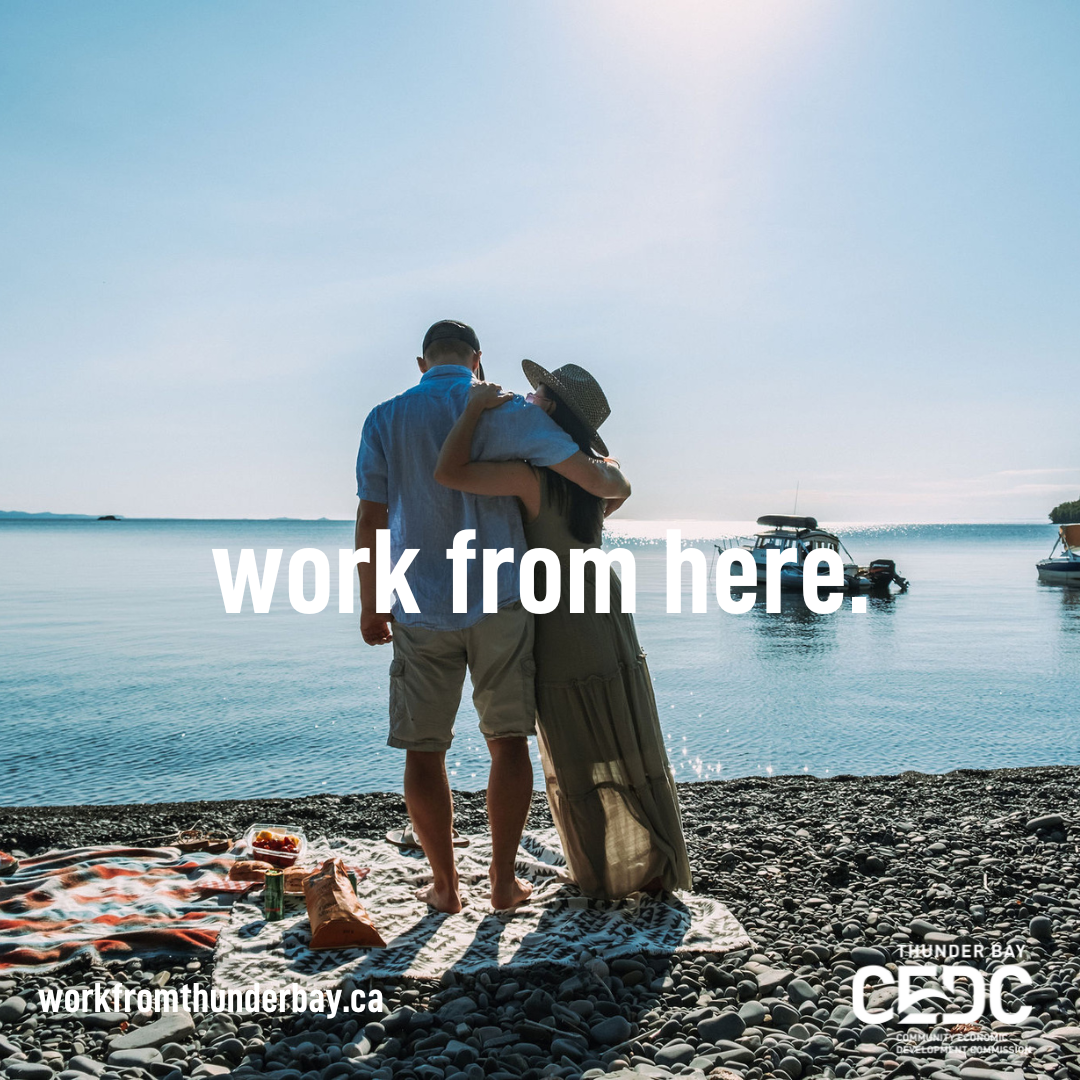 text over image: work from here Image: a man and woman hugging on a rocky beach on lake superior
