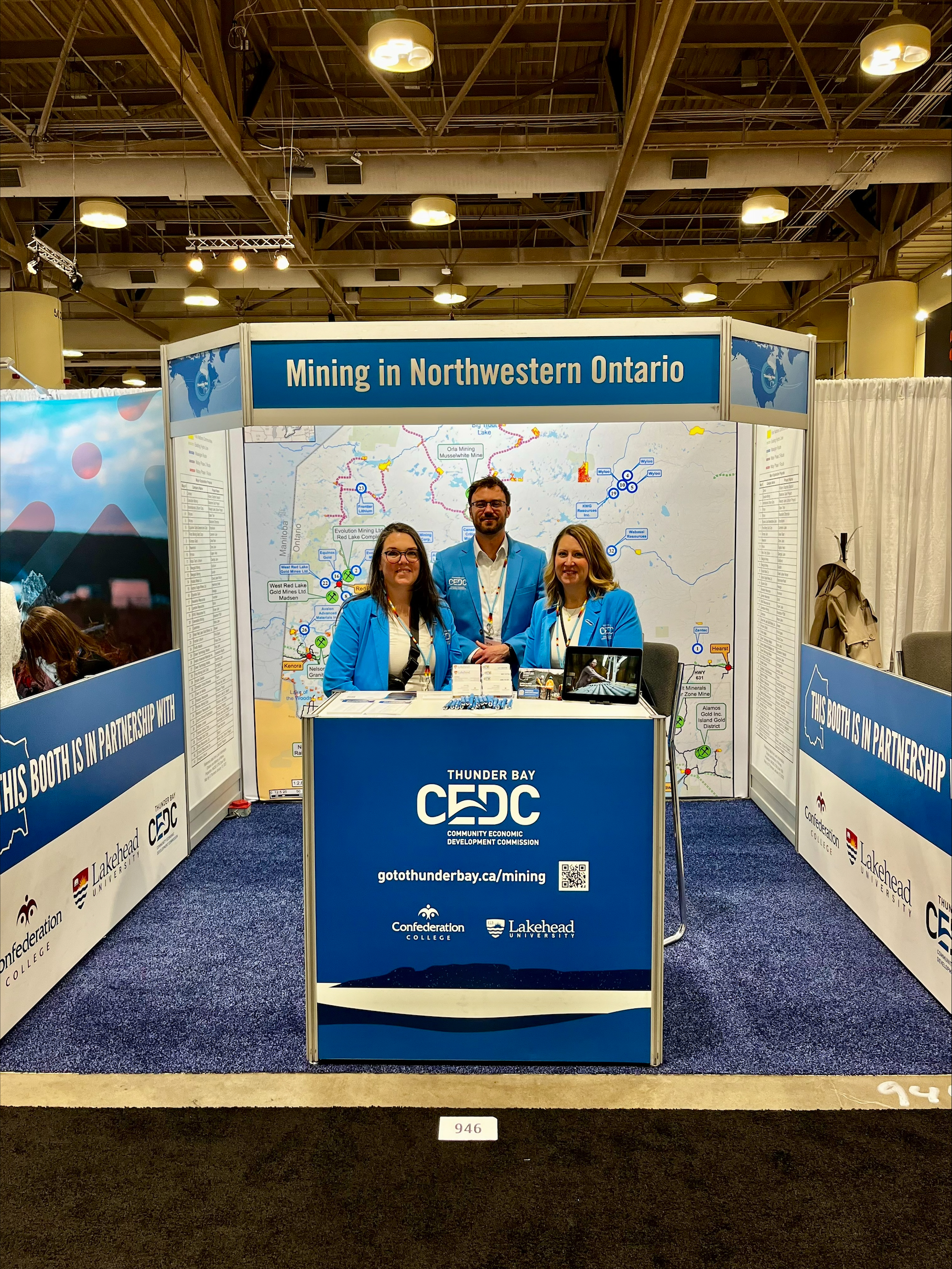 three CEDC staff standing at booth