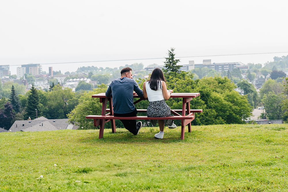 male & female sitting on a picnic table
